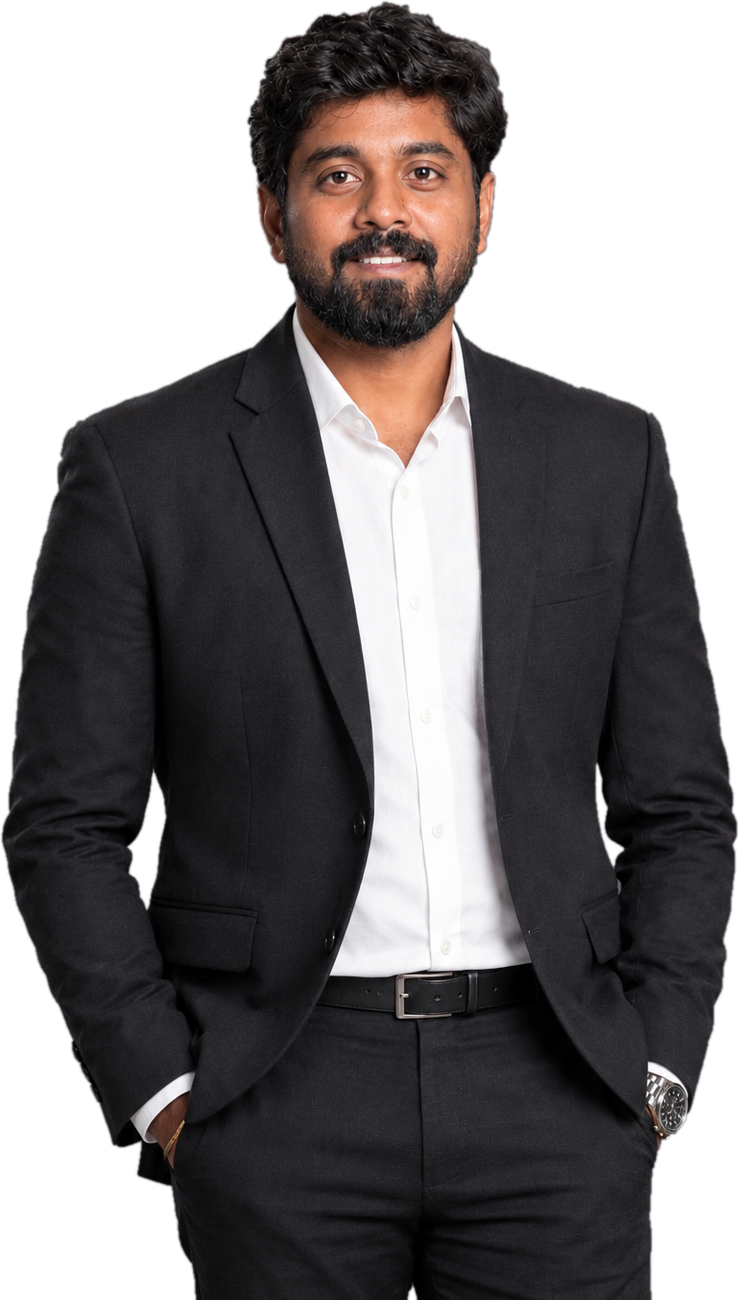Chanakian in a dark suit and white shirt, hands in pockets, smiling